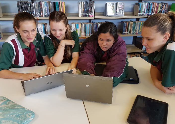 A number of school students working on the laptops