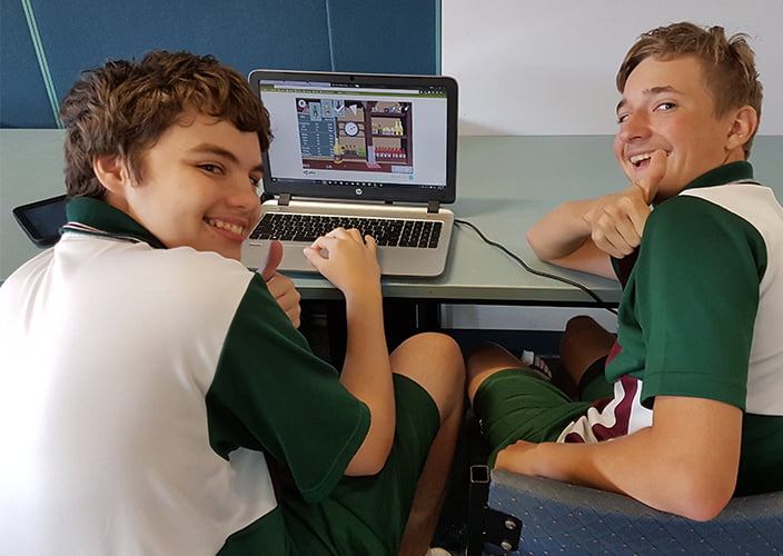 A couple students playing a game on their laptop